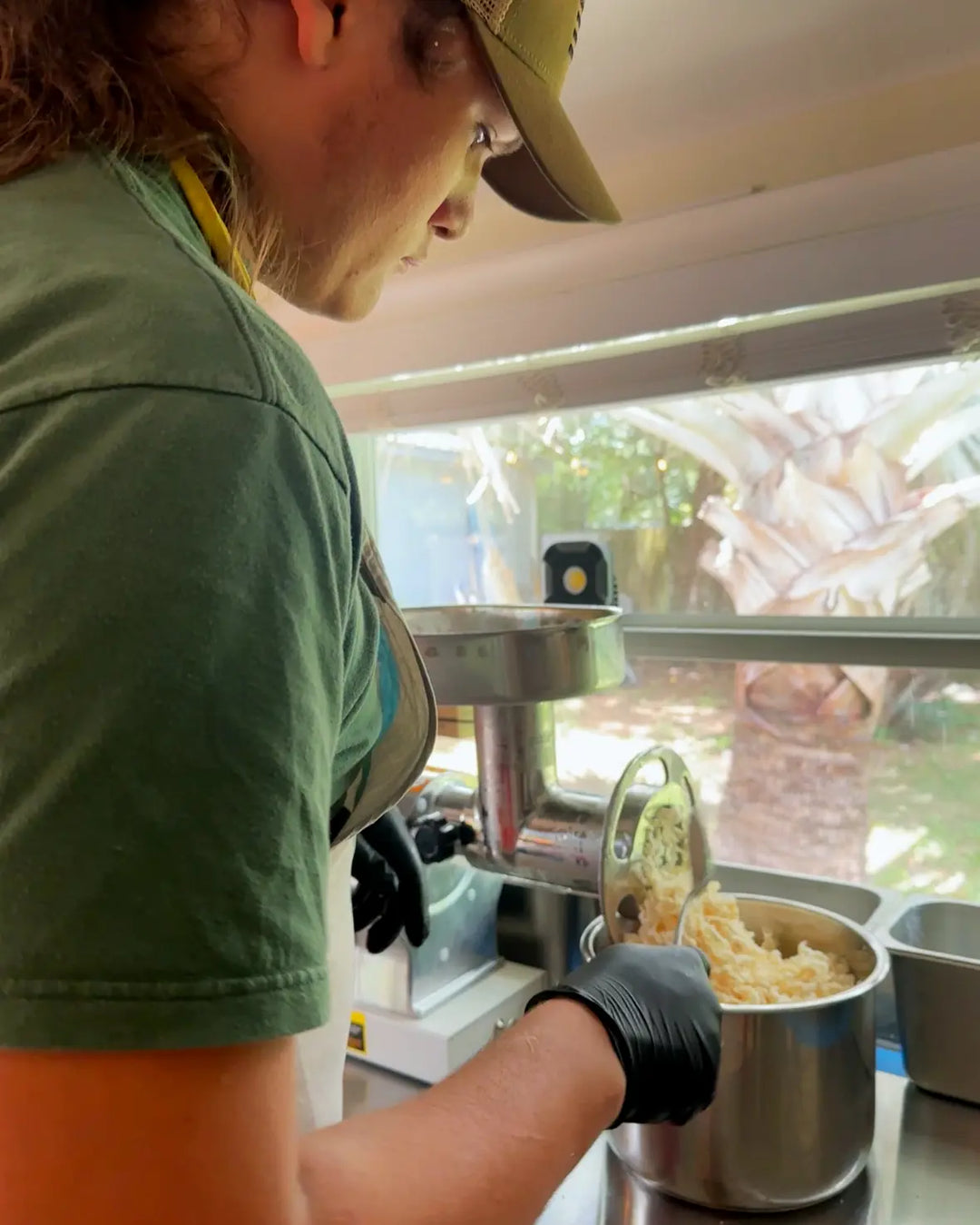 Family member grinding grass-fed suet by hand while preparing a small batch of tallow.