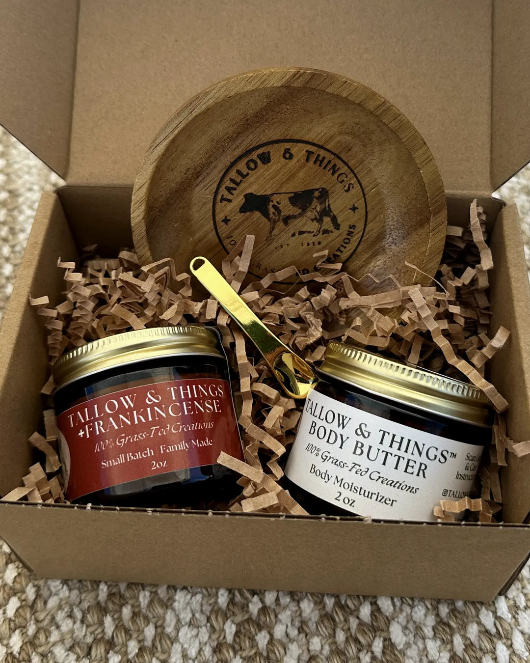Open Tallow and Things gift box with frankincense moisturizer, body butter, and a branded wooden dish.