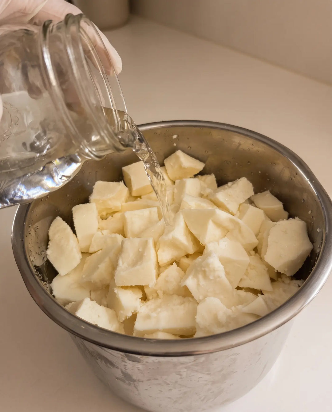 Alkaline water poured over cream-colored tallow during the rendering wash.
