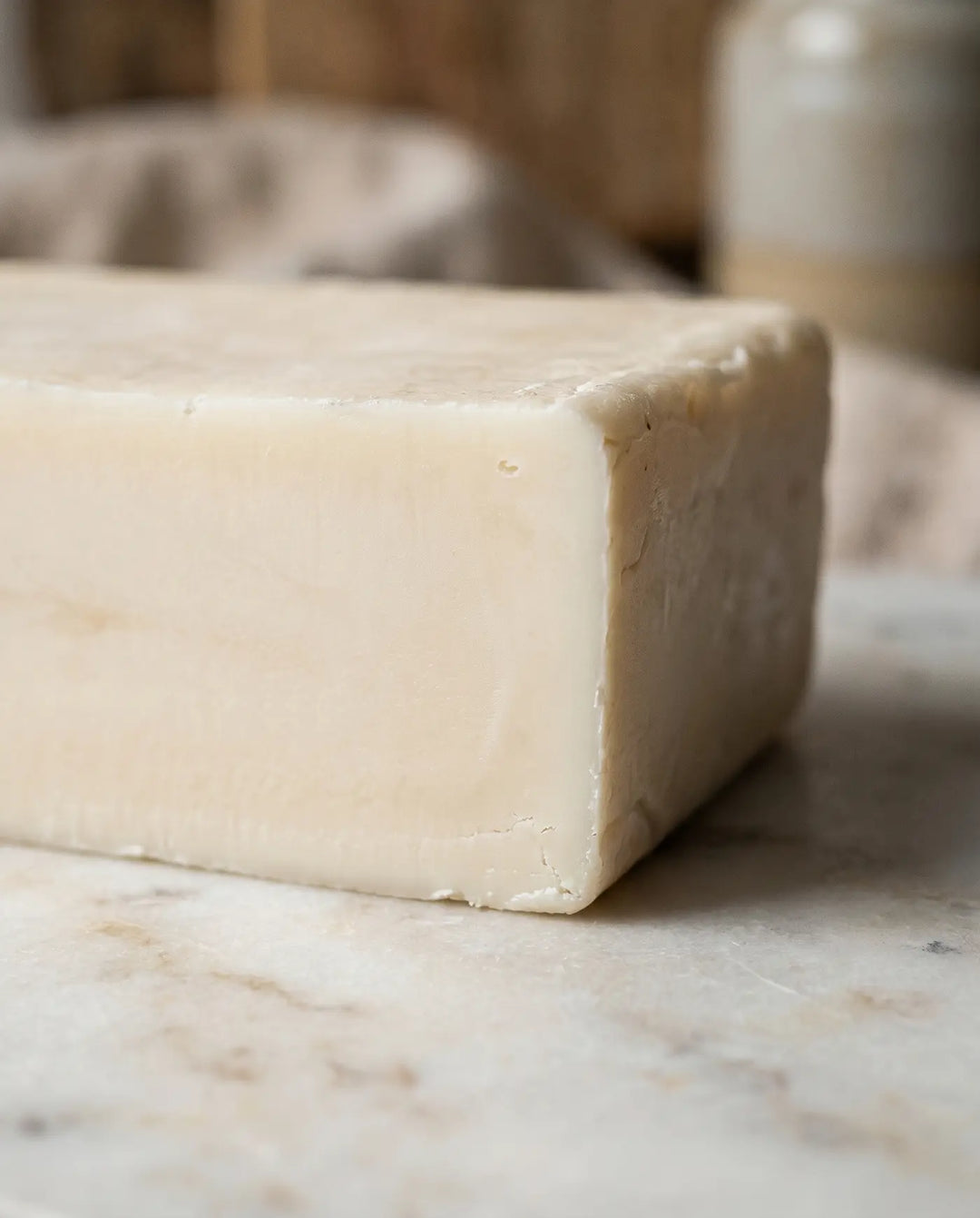 Macro of the firm matte cut edge of a dense pure cream-colored tallow block