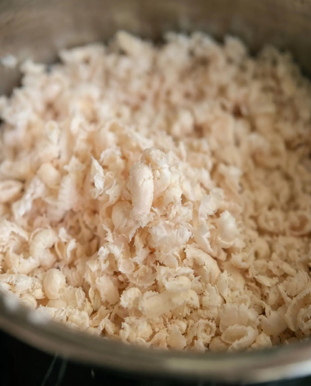 Close-up of clean uniform pale ground suet curls in a steel bowl