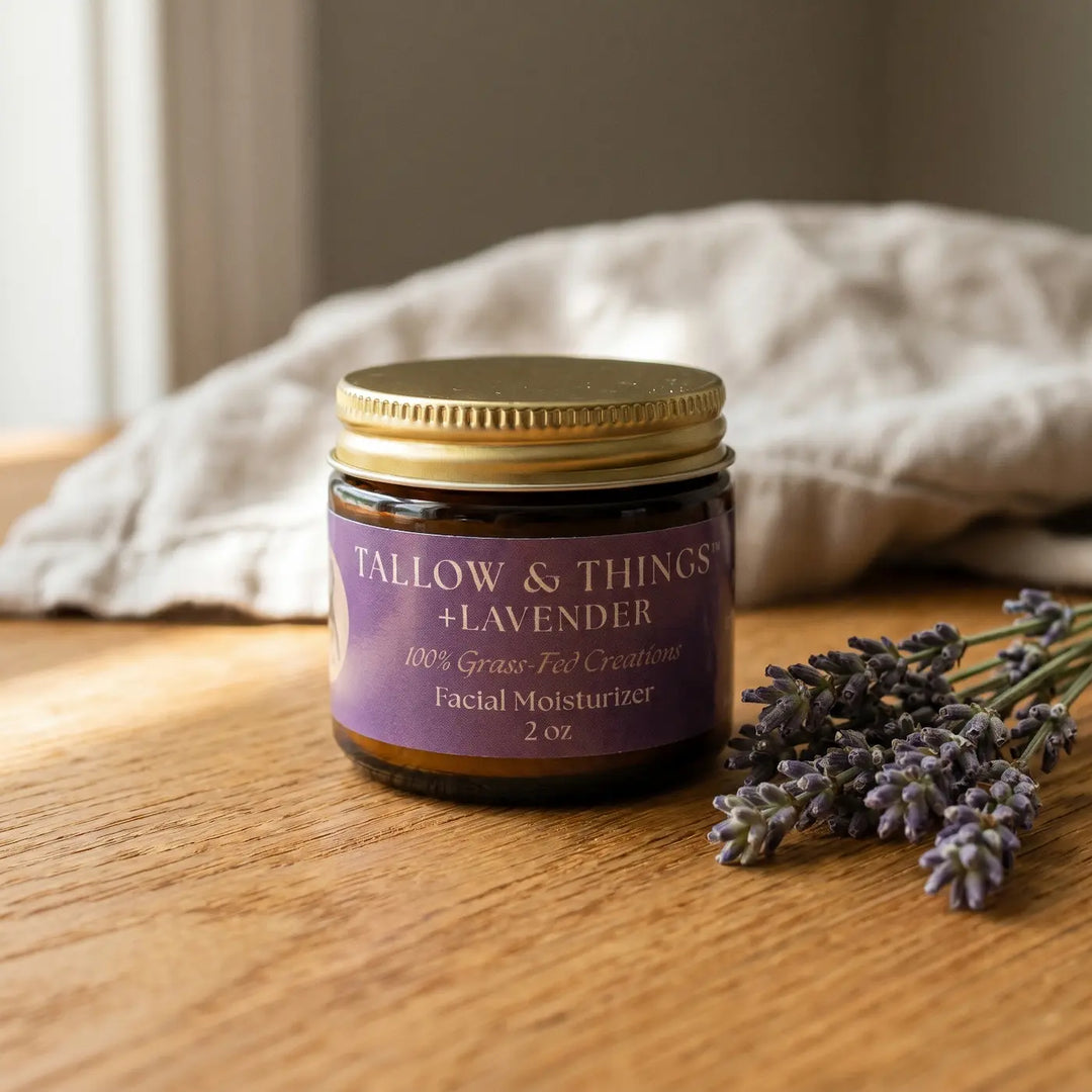 Lavender tallow facial moisturizer 2oz jar on oak wood with fresh lavender sprigs.