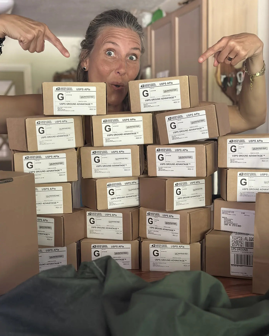 Founder beside a wall of packed orders ready to ship to customers